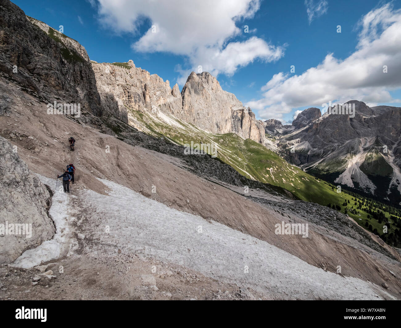 Trekkers enjoy the rugged mountain scenery en-route to the Rotwand hut mountain refuge in the Rosengarten area of the Italian Dolomites the Alto Adige Stock Photo