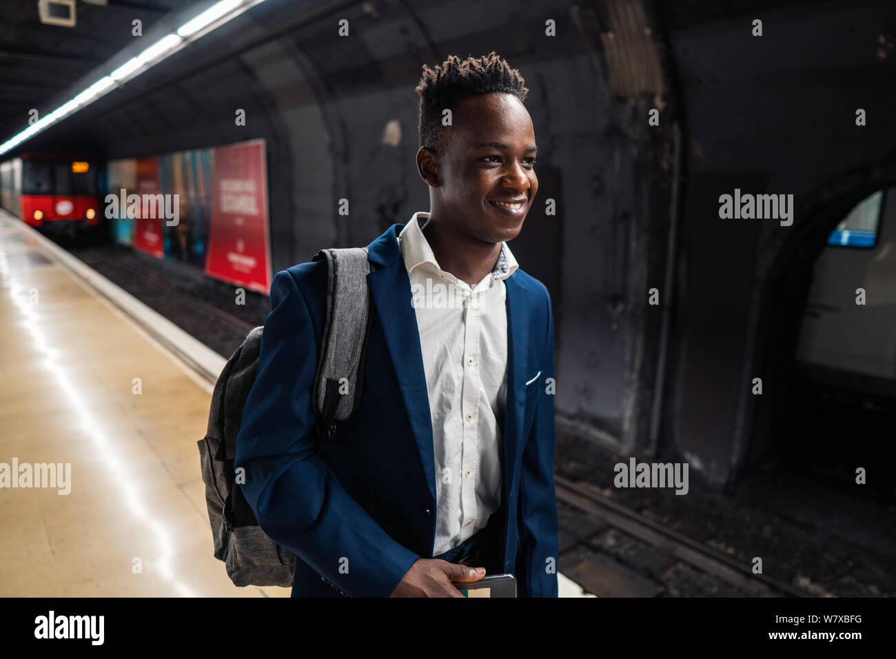 African American businessman wearing blue suit and backpack Stock Photo