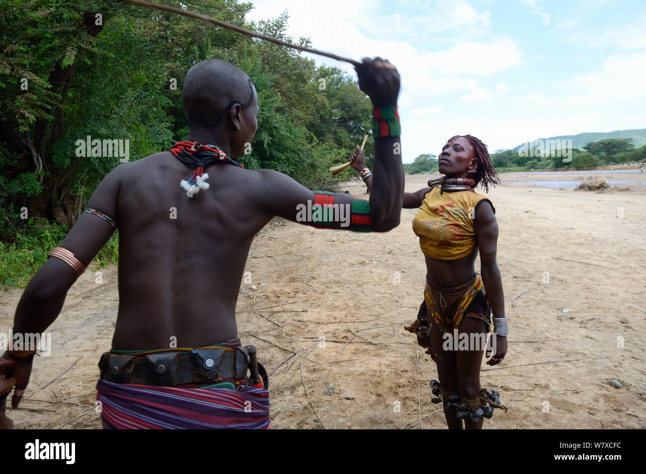 During the Ukuli ceremony and before the bull jumping, the Maza (young initiated men) whip the Hamer women who will defy them, showing no fear or signs of pain. Hamer tribe, Omo river Valley, Ethiopia, September 2014. Stock Photo
