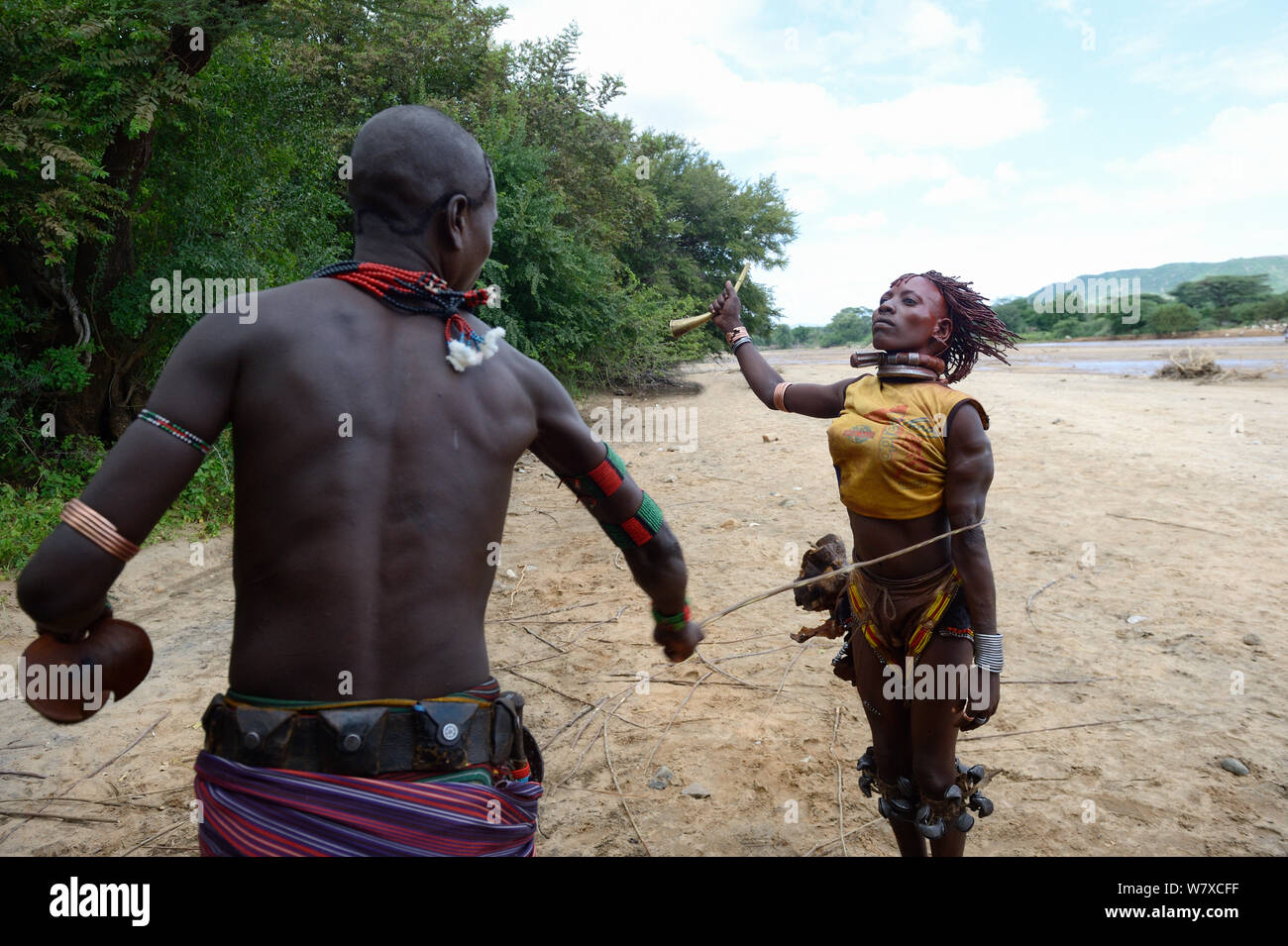 During the Ukuli ceremony and before the bull jumping, the Maza (young initiated men) whip the Hamer women who will defy them, showing no fear or signs of pain. Hamer tribe, Omo river Valley, Ethiopia, September 2014. Stock Photo