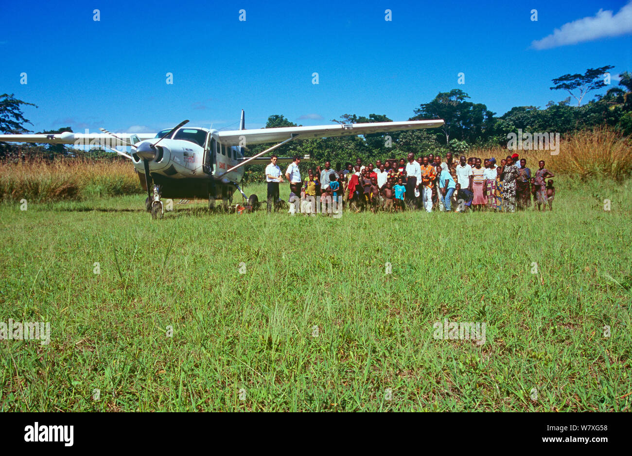 Batwa Pygmy villagers on Monkoto airstrip with &#39;Aviation Sans Frontier&#39; pilots and plane. Democratic Republic of the Congo, 2008-2009. Stock Photo