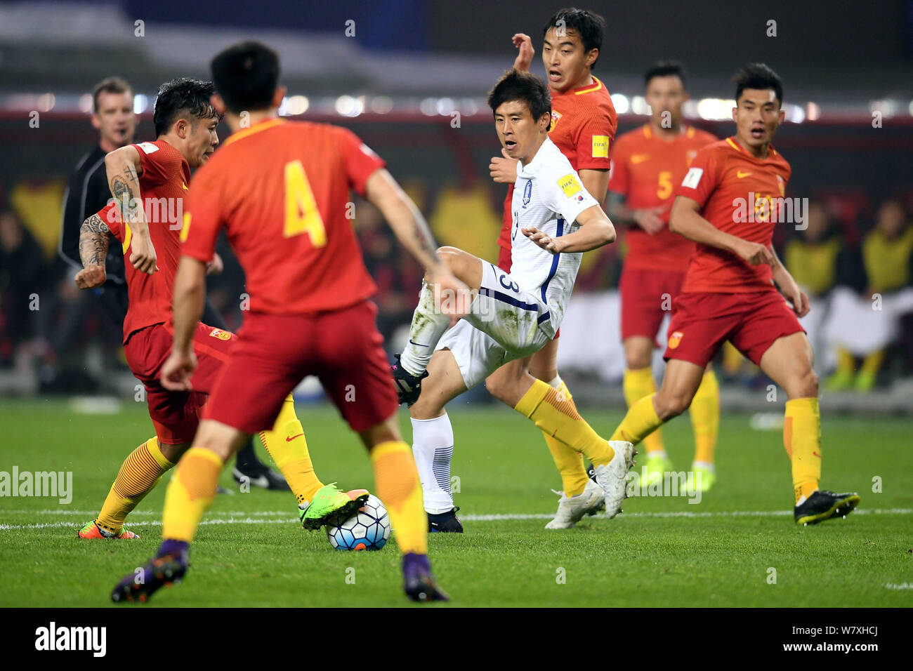 Players of Chinese national men's football team challenge Kim Jin-su of South Korea national football team in their Group A Round 6 match during the F Stock Photo