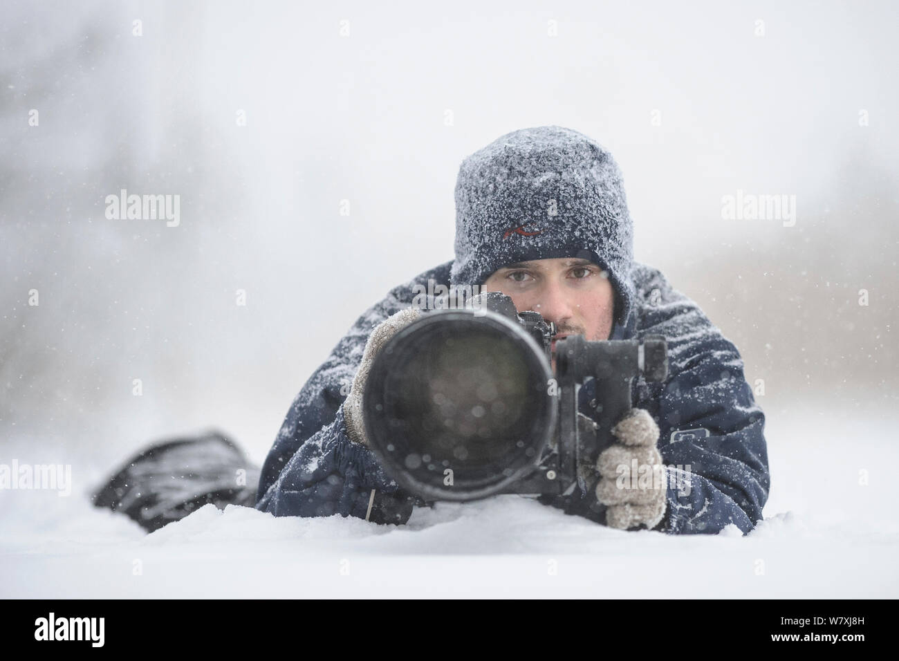 Photographer Sven Zacek with camera in the snow. Stock Photo