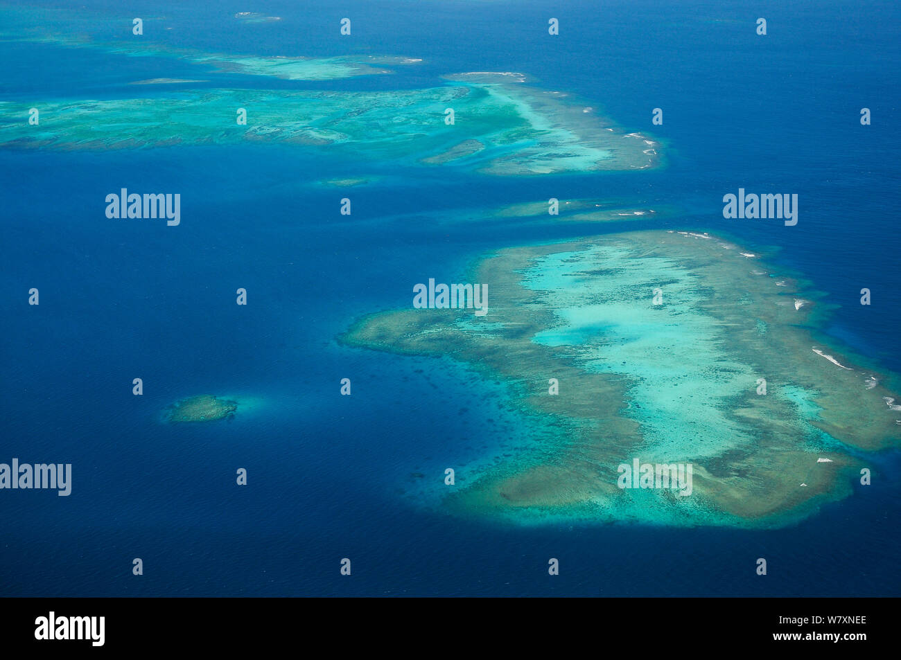 Aerial view of atolls with surrounding coral reefs, off the coast of New Caledonia, September 2008 Stock Photo