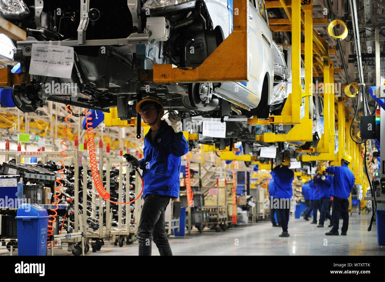 Chinese workers assemble cars on the assembly line at an auto plant of ...