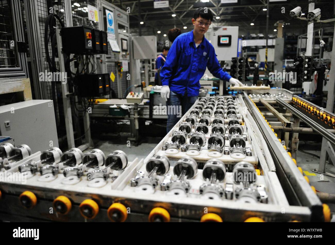 A Chinese worker assembles cars on the assembly line at an auto plant ...
