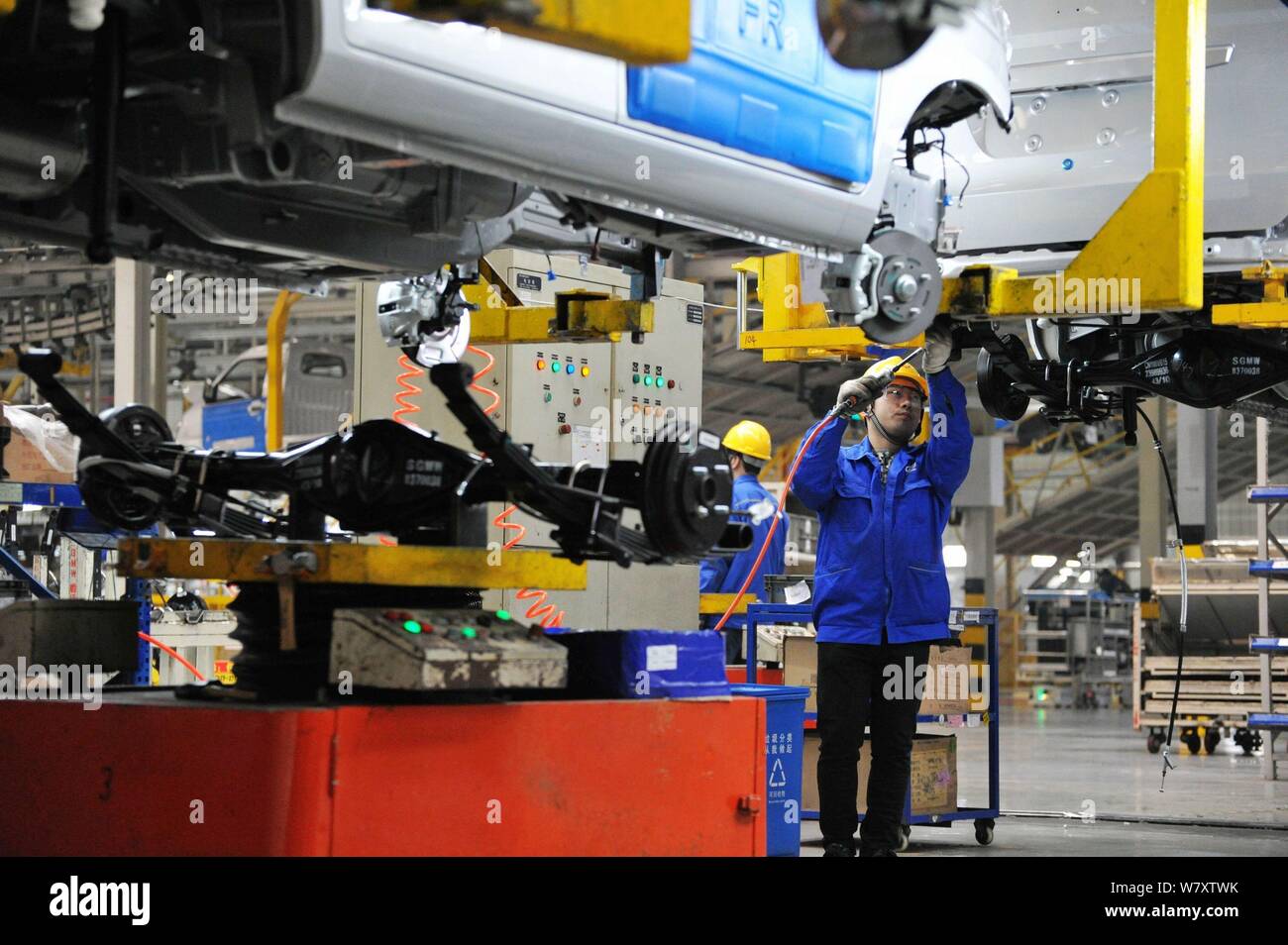 A Chinese worker assembles cars on the assembly line at an auto plant ...