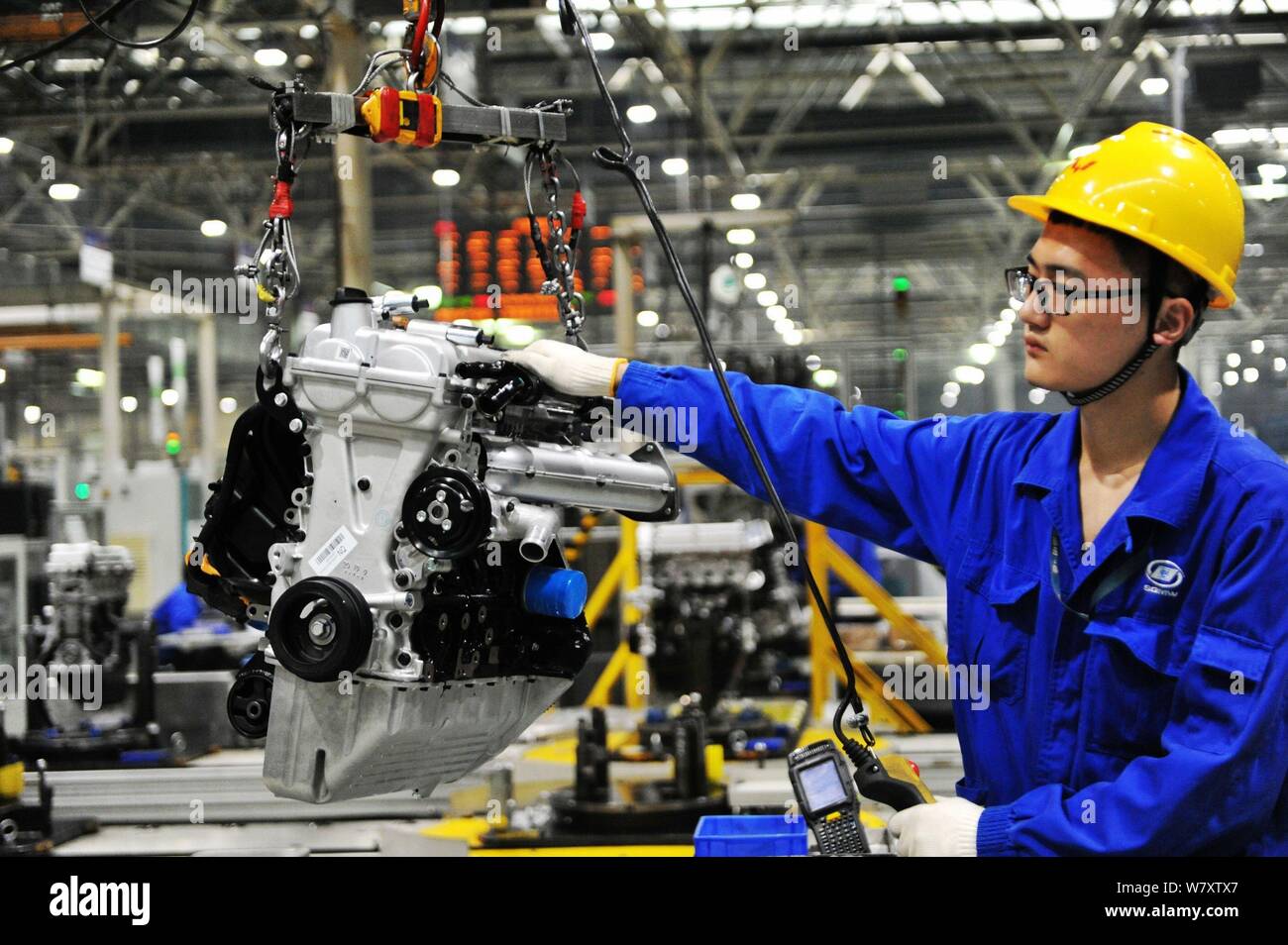 A Chinese worker assembles cars on the assembly line at an auto plant ...