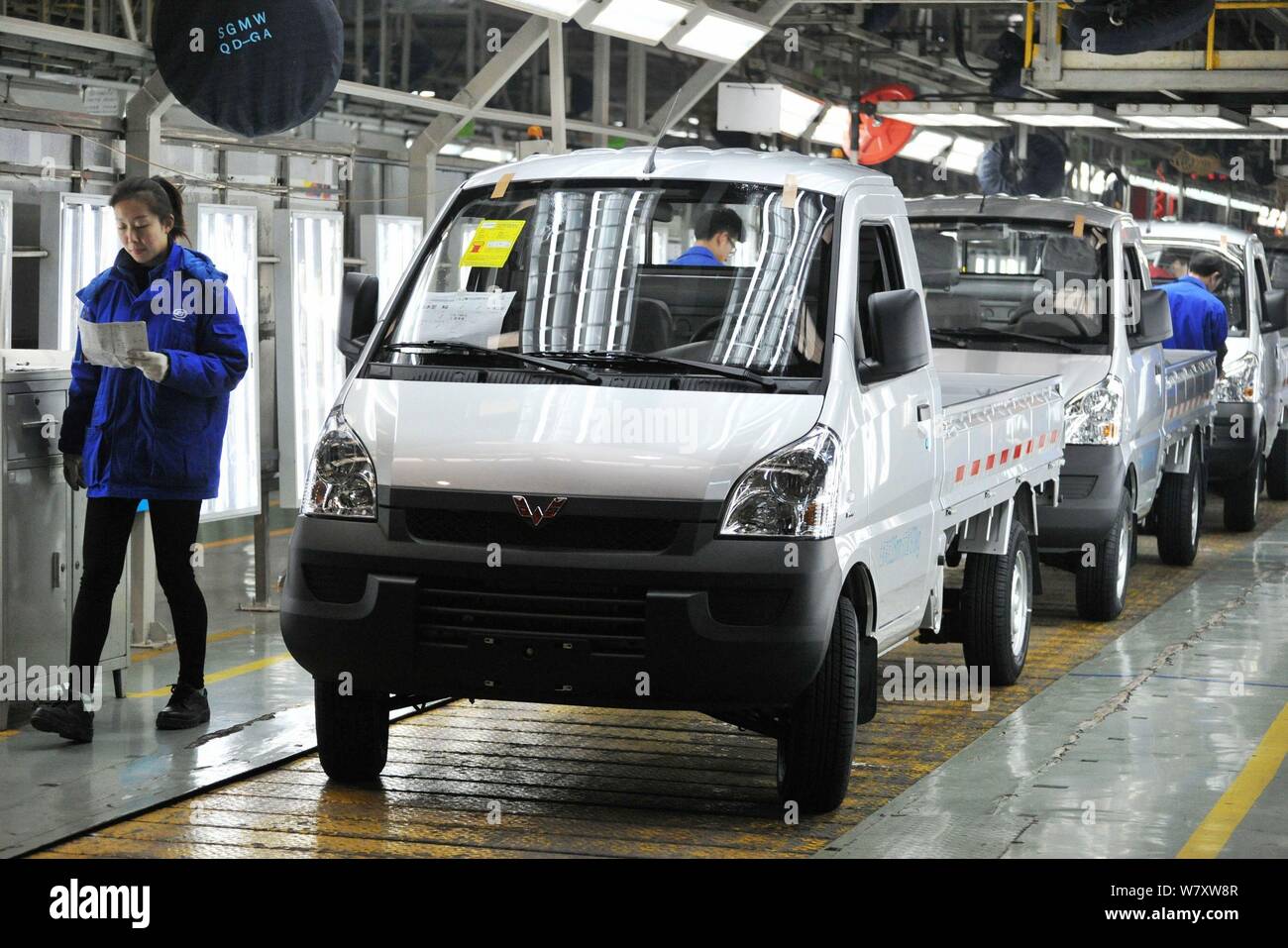 Chinese workers assemble cars on the assembly line at an auto plant of ...