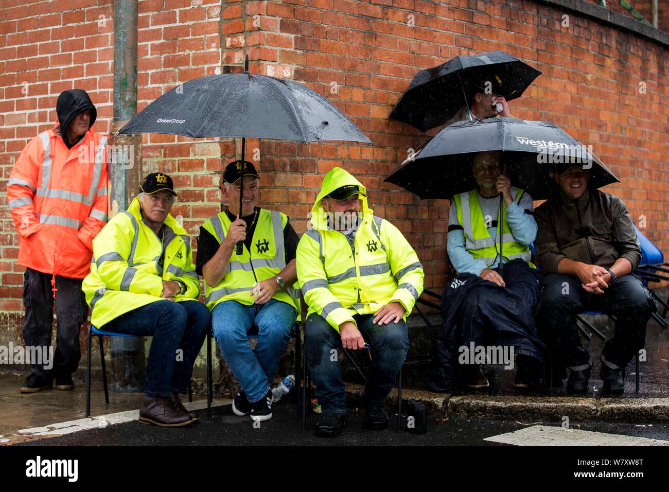 Harland and Wolff workers listen to Irish singer songwriter Tommy Sands performing at the gates of Harland and Wolff shipyard, Belfast, in support of the workers who are calling for the shipyard to be renationalised, as there has been deluge of support from donations of suncream and food to performances by local celebrities. Stock Photo