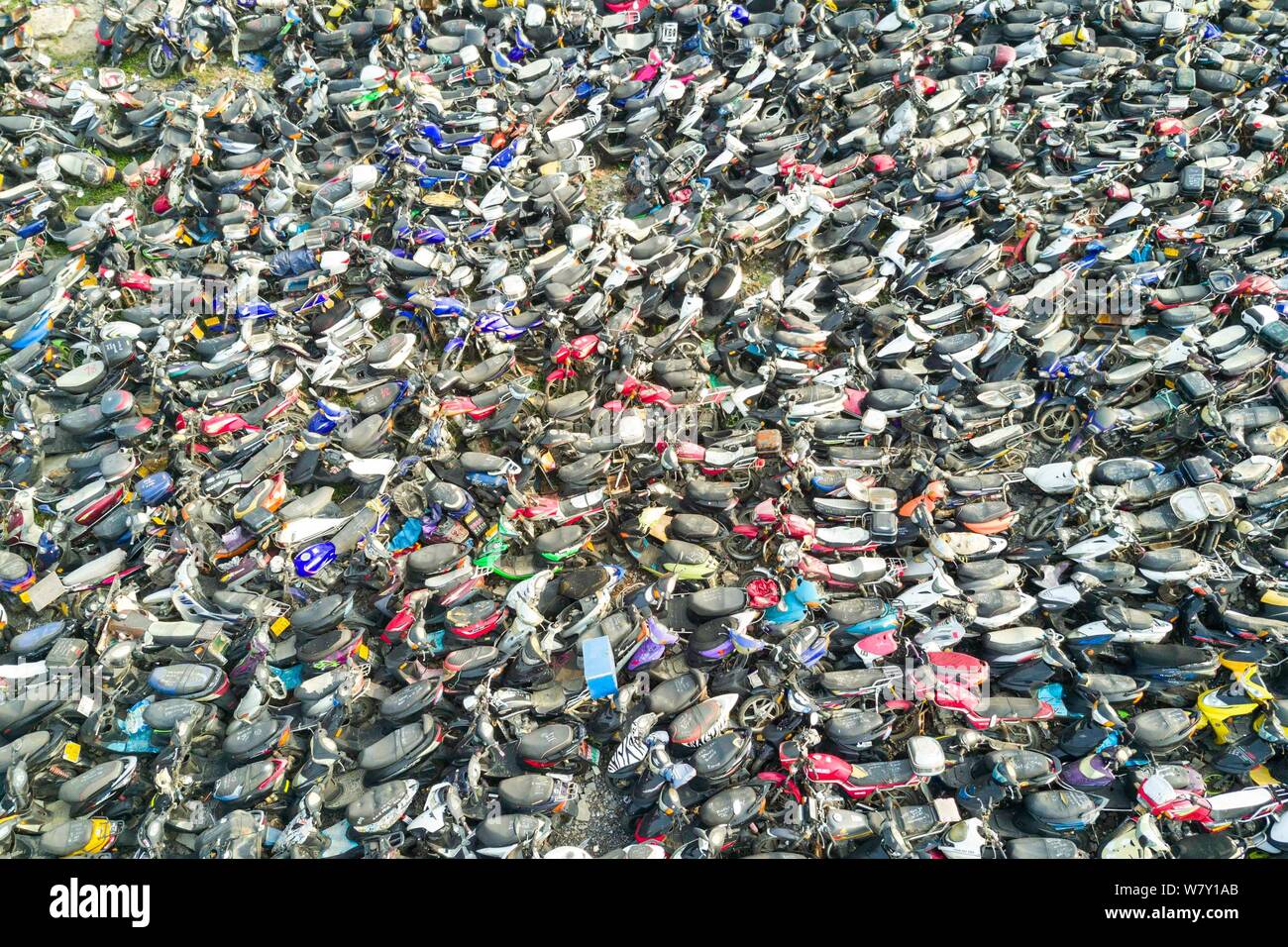 Aerial view of a vehicle junkyard piled high with cars and motorcycles