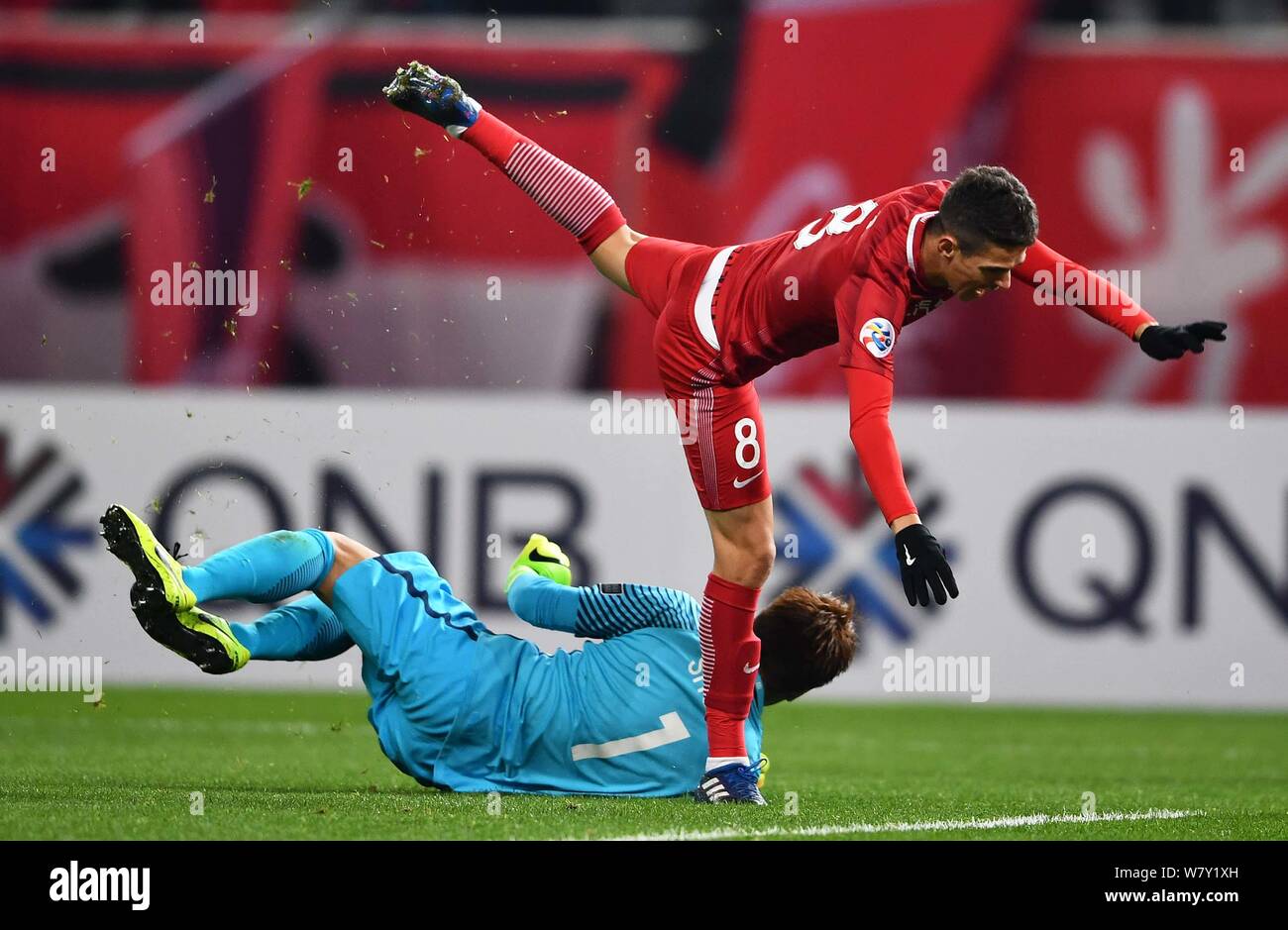 Oscar of China's Shanghai SIPG, right, is stumbled by Shusaku Nishikawa of Japan's Urawa Red Diamonds in their Group F match during the AFC Champions Stock Photo