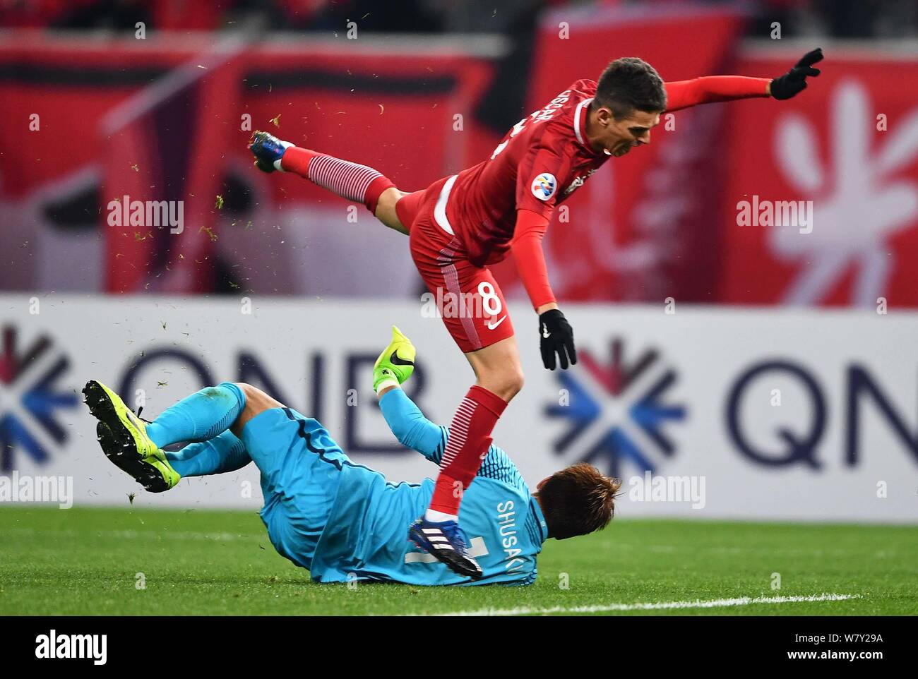 Oscar of China's Shanghai SIPG, right, is stumbled by Shusaku Nishikawa of Japan's Urawa Red Diamonds in their Group F match during the AFC Champions Stock Photo