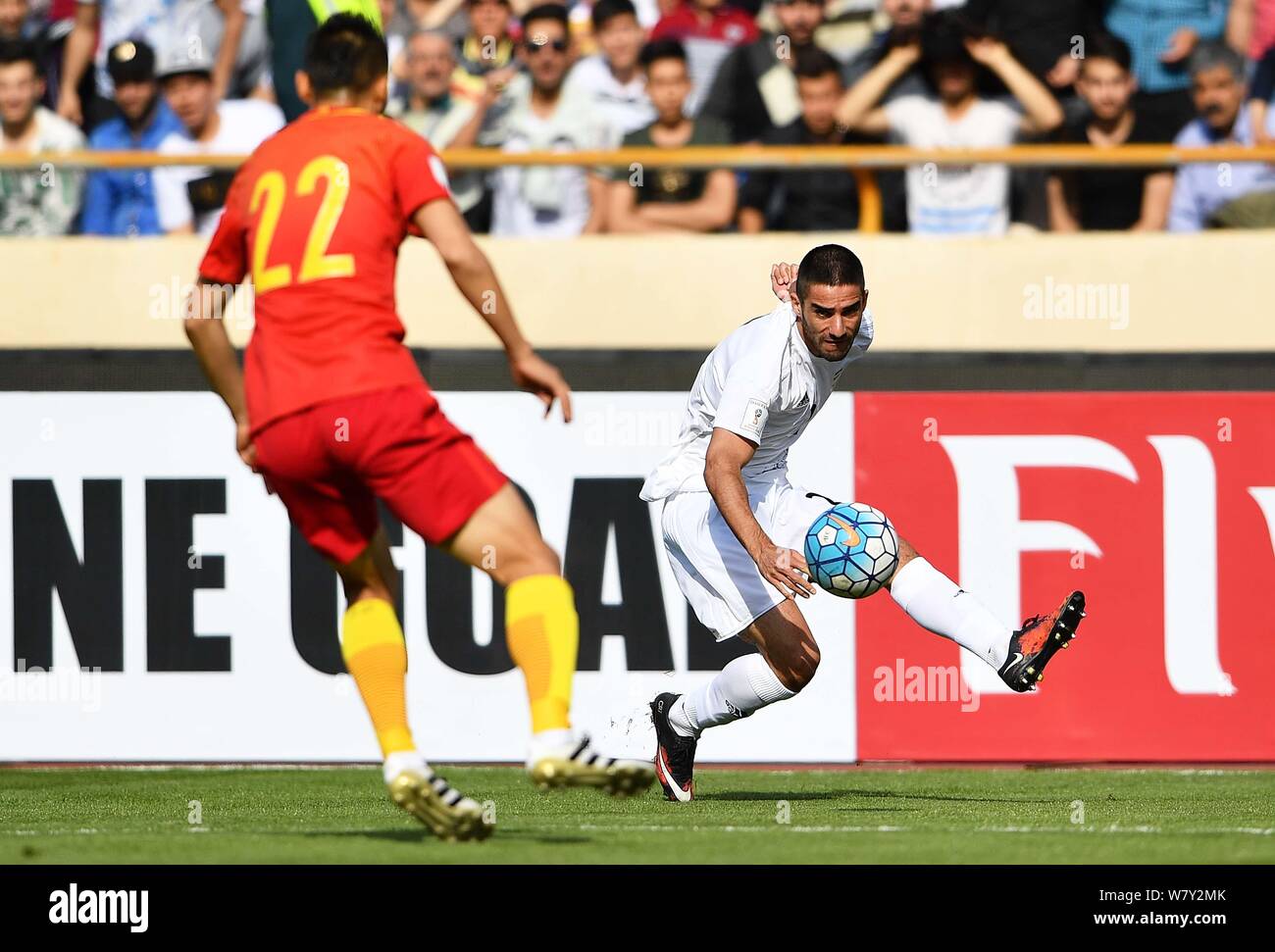 Milad Mohammadi of Iran, right, challenges Yu Dabao of China in their Group A Round 7 match during the FIFA World Cup 2018 Asian Qualifiers in Tehran, Stock Photo