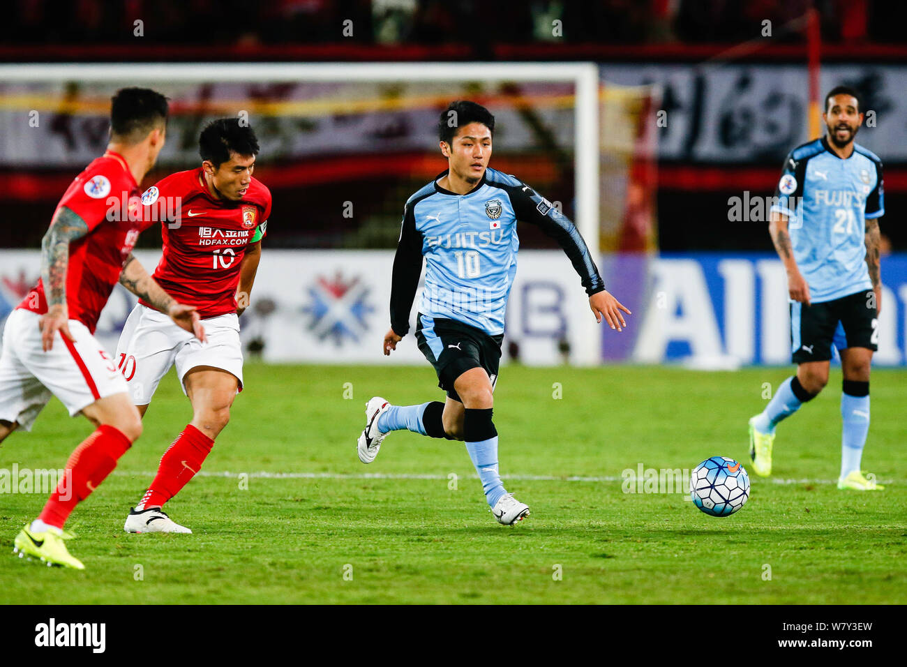 Ryota Oshima of Japan's Kawasaki Frontale F.C., second right, dribbles against China's Guangzhou Evergrande F.C. in their Group G match during the AFC Stock Photo