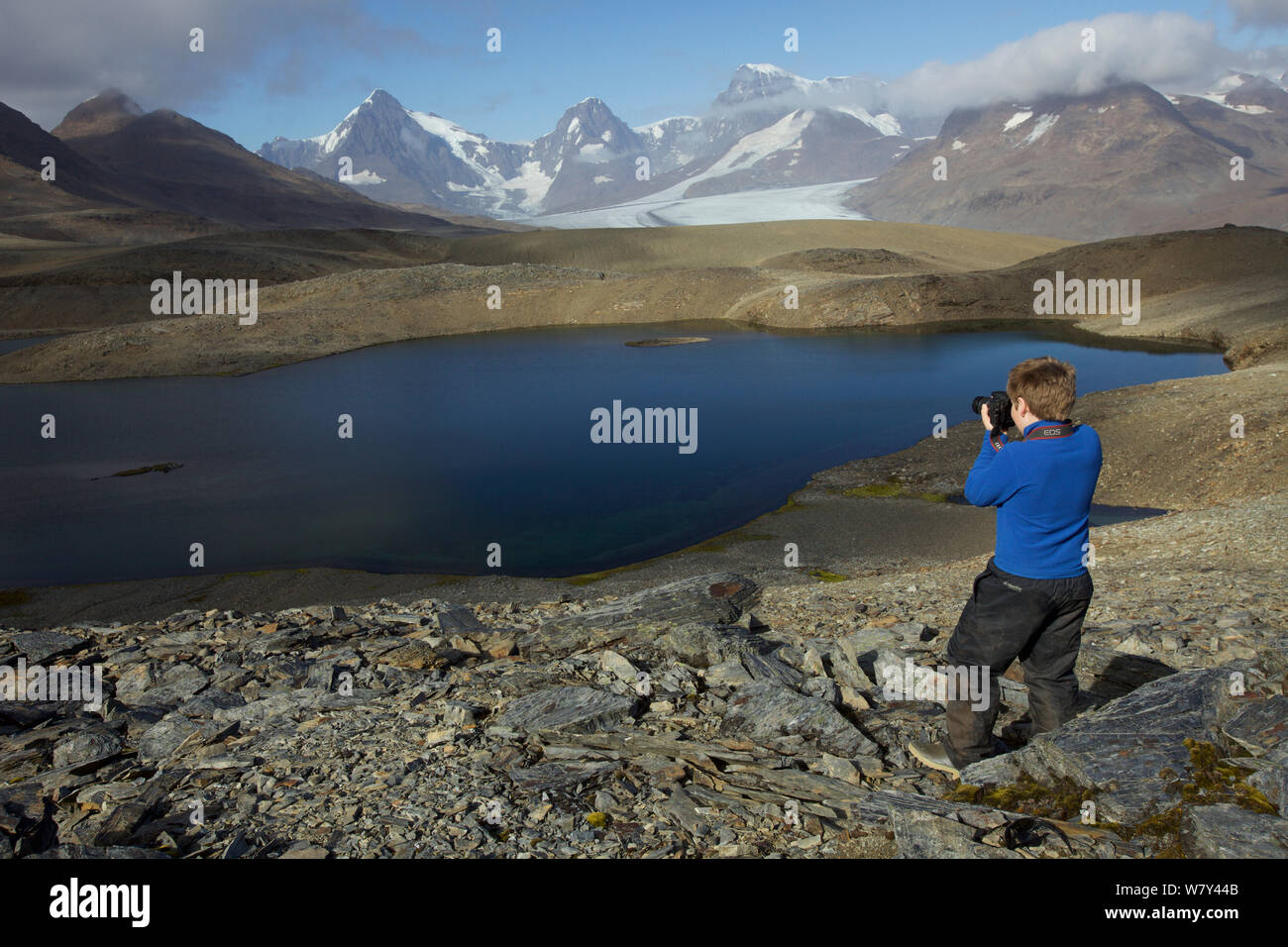 Russell Laman photographing Crean Lake on the hike between Fortuna Bay and Stromness, retracing part of Shackleton&#39;s route. South Georgia, February 2011. Model released. Stock Photo