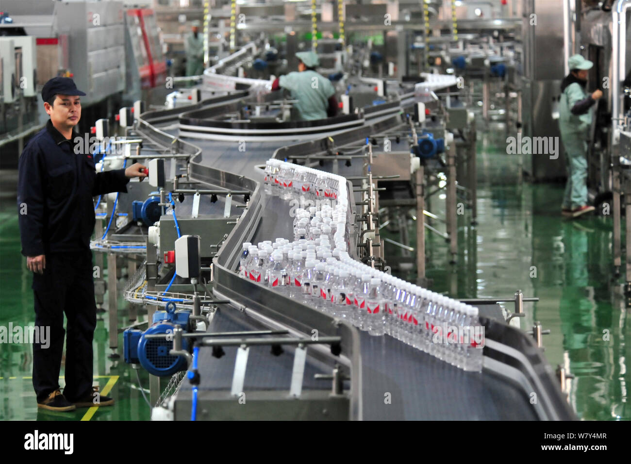 --FILE--A Chinese worker checks bottles of Wahaha purified water on the ...