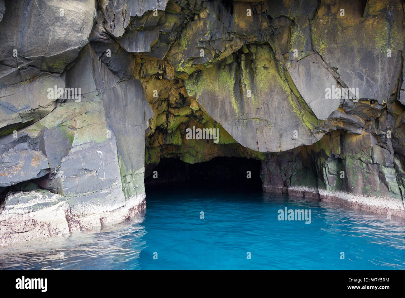 Sea cave with vivid blue sea outside. Mykines, Faroe Islands, North Atlantic. July. Stock Photo