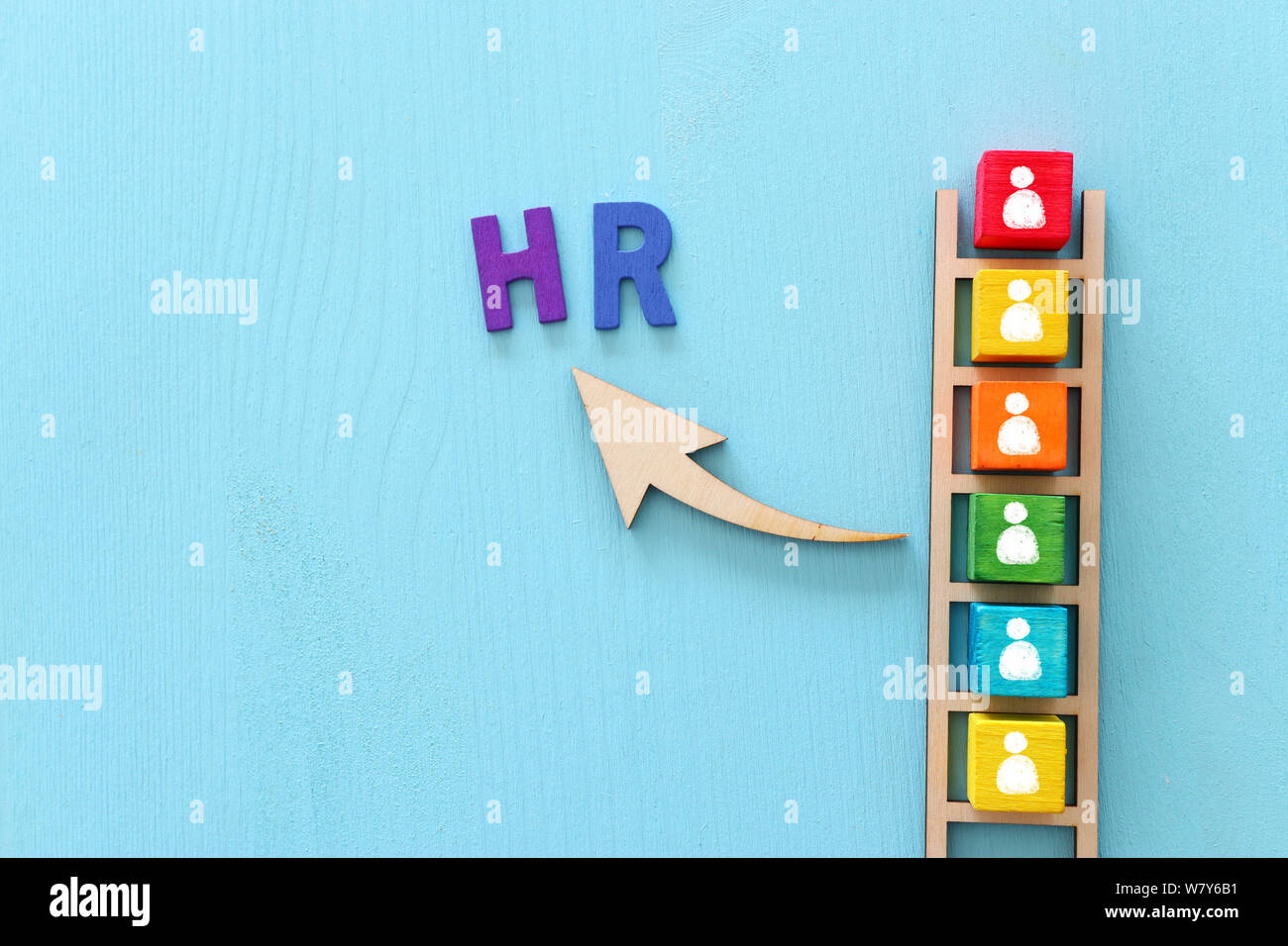 Business image of wooden ladder with people icons over blue table ...