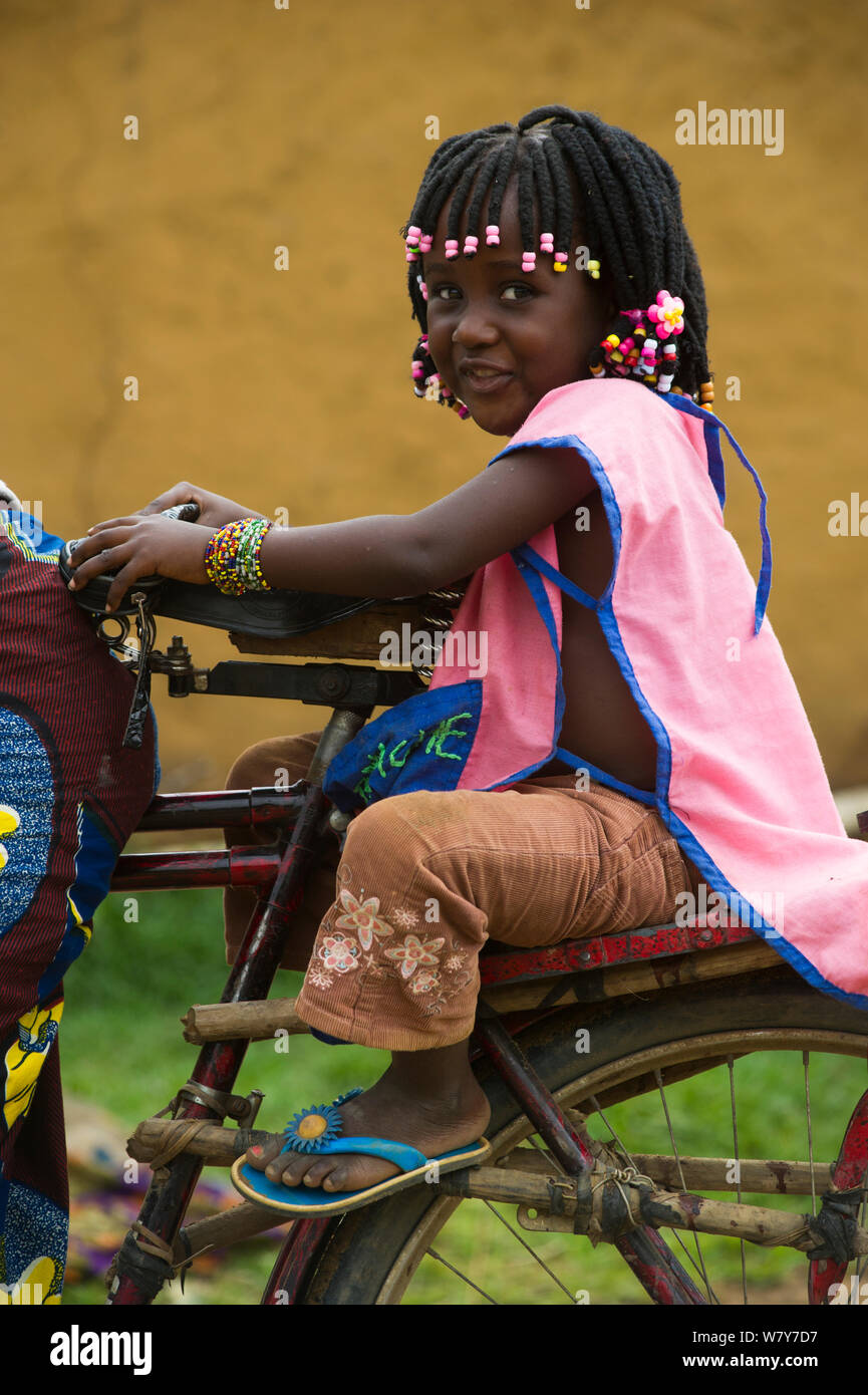 Young girl on back of bicycle, Mbomo Village, Odzala-Kokoua National Park, Republic of Congo (Congo-Brazzaville), Africa, May 2013. Stock Photo