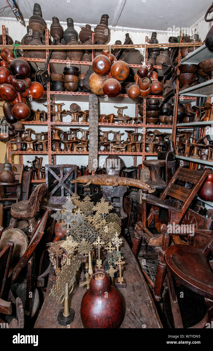 Interior of a toursit shop in Addis Ababa featuring various items such as Coptic crosses, headrests, bottle gourds, wooden chairs, a stuffed crocodile and various wood carvings, which the seller claimed to be antique. Addis Ababa, Ethiopia. February 2009 Stock Photo