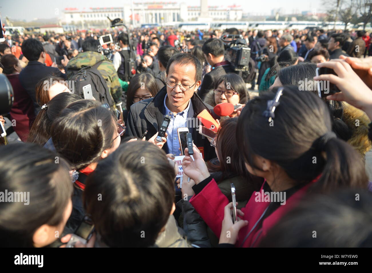 Michael Yu Minhong, center, founder and CEO of New Oriental Education & Technology Group, is surrounded by reporters as he arrives at the Great Hall o Stock Photo