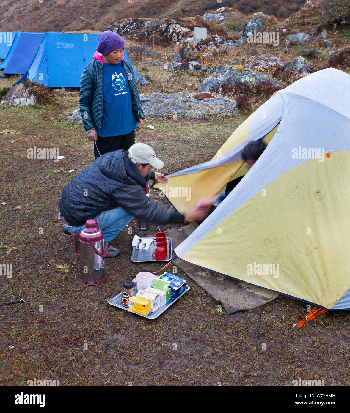 Morning tea served to trekking clients at Camp Jangothang on the Jhomolhari Trek.  Bhutan, October 2014. Model released. Stock Photo