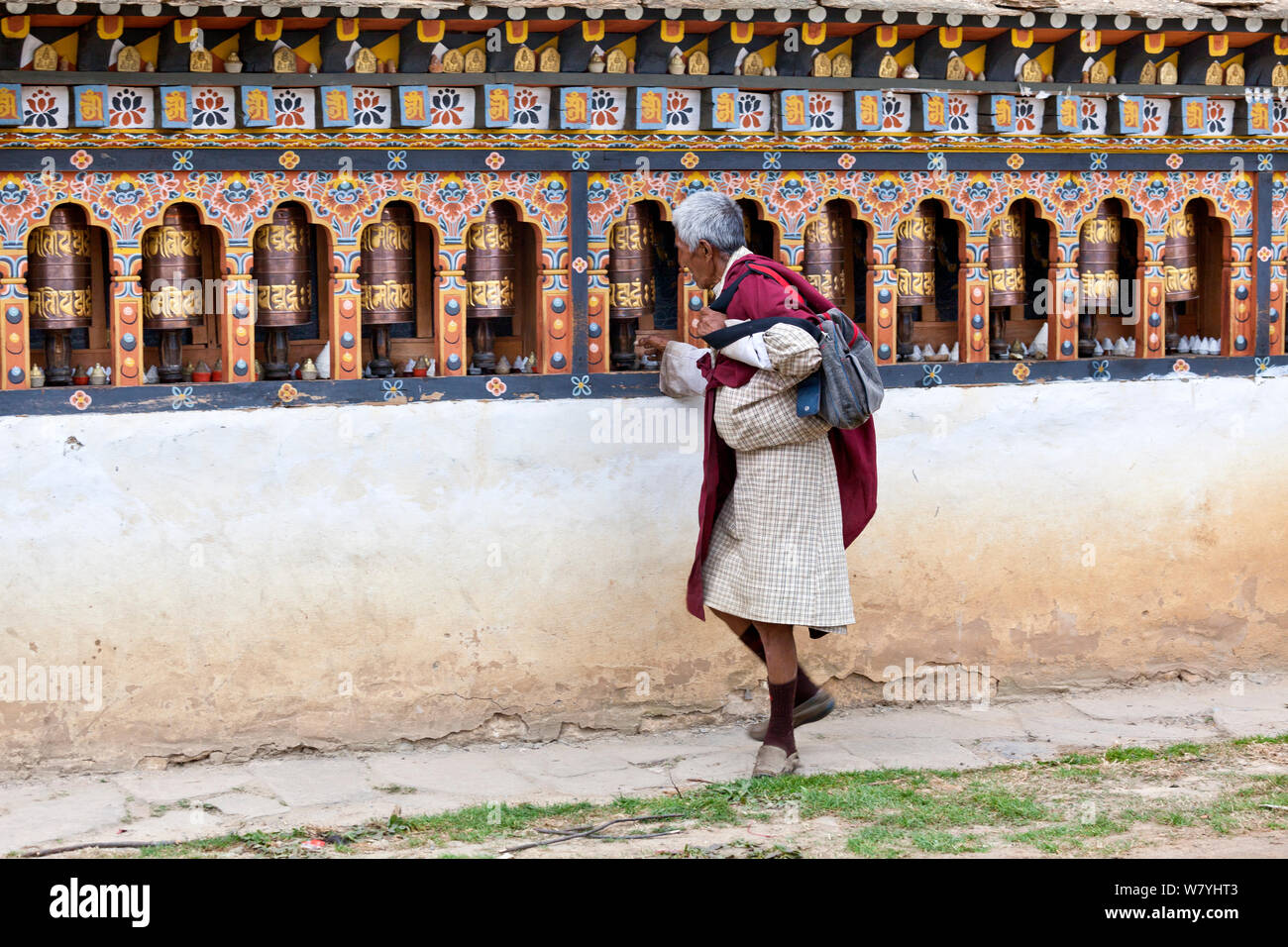 Man spinning prayer wheels at Kyichu Lhakhang in Paro, Bhutan, October 2014. Stock Photo