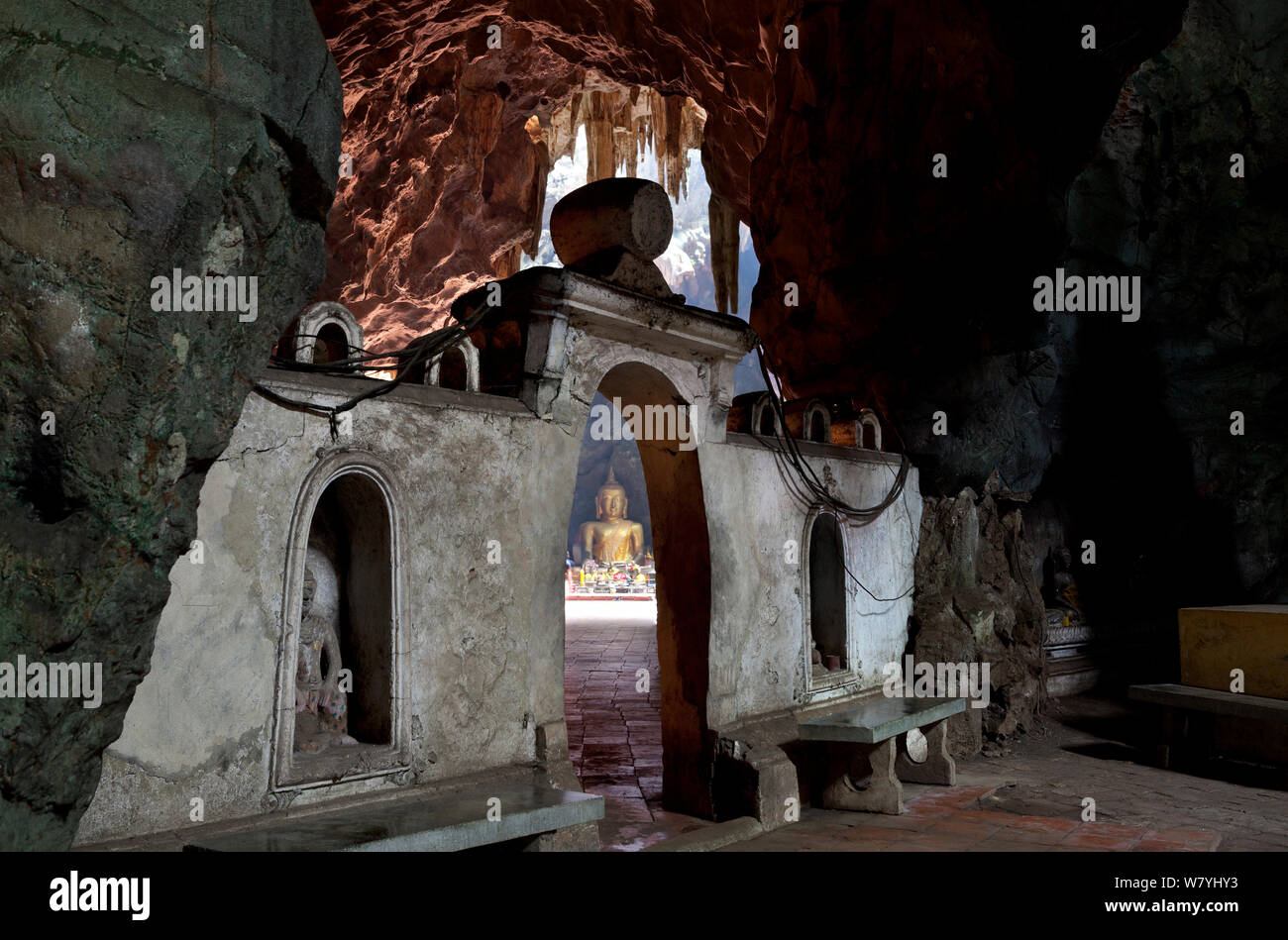 Buddhist shrine in Khao Luang Cave with daylight lighting up figure of the Buddha. Phetchaburi, Thailand, September 2014. Stock Photo