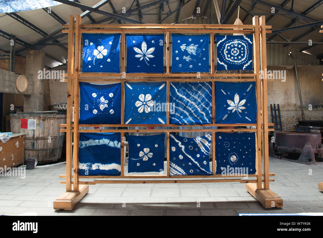 Dyed cloths are hung on racks in the sun for drying after a machine has