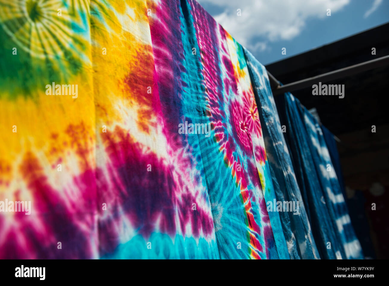 Dyed cloths are hung on racks in the sun for drying after a machine has