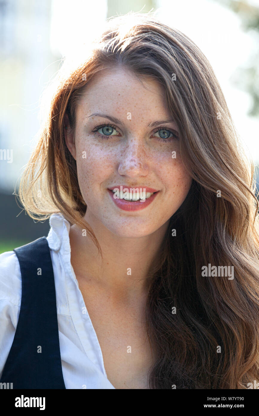 Pretty girl with freckles on her face is smiling to you Stock Photo