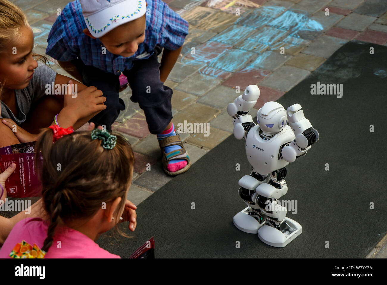 Kremenchuk, Ukraine - 3.08.2019: Demonstration of high technology of the future, The Smart UBTECH Humanoid Robot surrounded by children, horizontal or Stock Photo