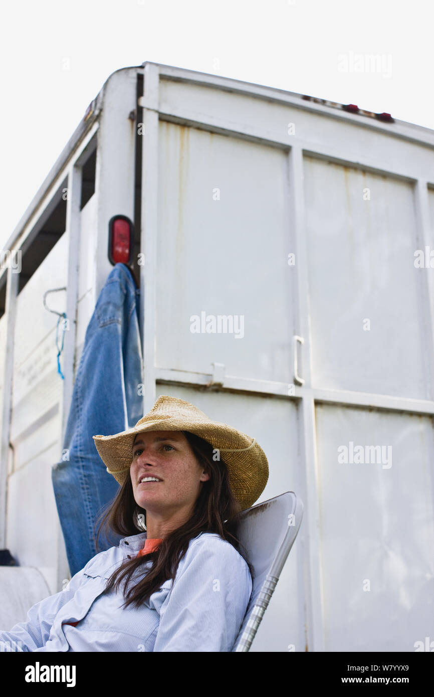Mid-adult woman sitting beside a horse float. Stock Photo