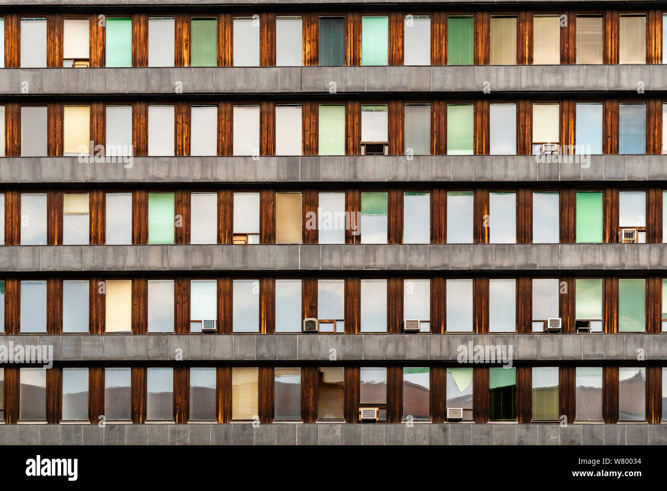 Evening reflections on small aligned windows. Architecture details. Stock Photo