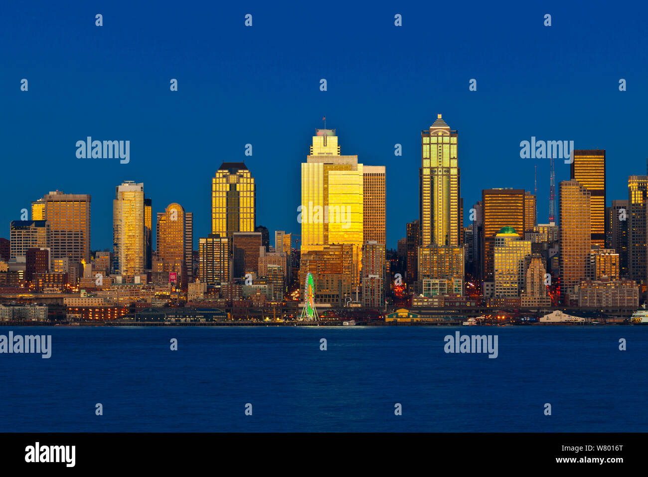 Sunset reflected  off  skyscrapers, viewed from across Elliott Bay, West Seattle, Washington, USA. December 2014. Stock Photo