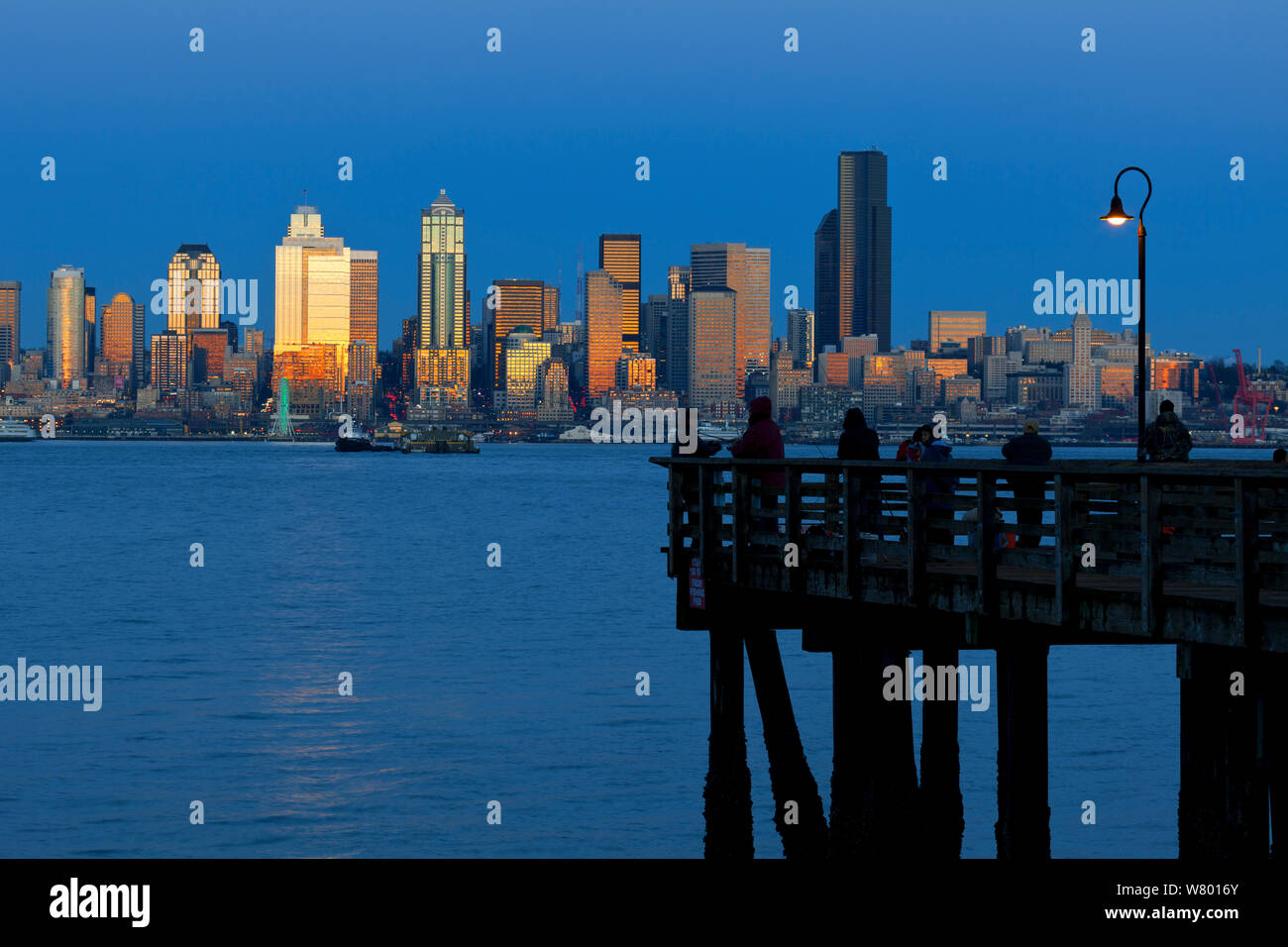 Sunset  reflecting off  skyscrapers, viewed from across Elliott Bay, West Seattle, Washington, USA. December 2014. Stock Photo