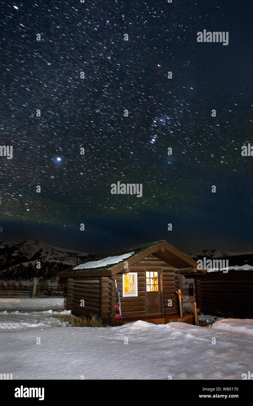 Cabin in snow on starry night, Buffalo Ranch, Lamar Valley, Yellowstone National Park, Wyoming, USA. February 2015. Stock Photo