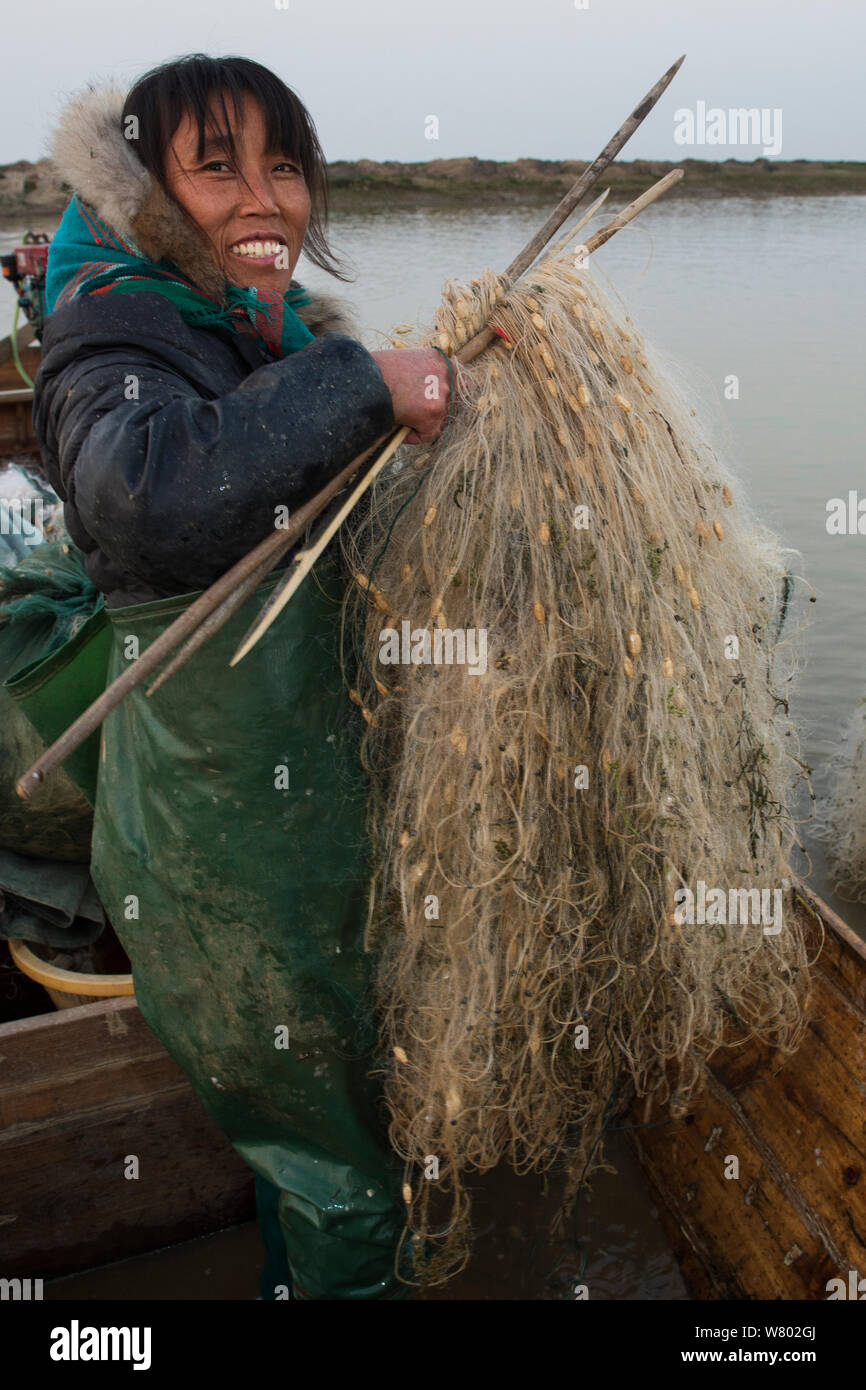 Fisherwoman mending her nets, Changshan Island, Poyang Ho Lake, Jiangxi province, China, December 2014. Stock Photo