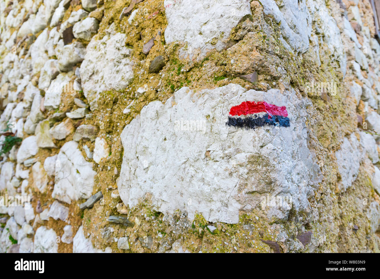 Red and black hiking trail marker on stone wall, Triglav National Park, Slovenia, October 2014. Stock Photo