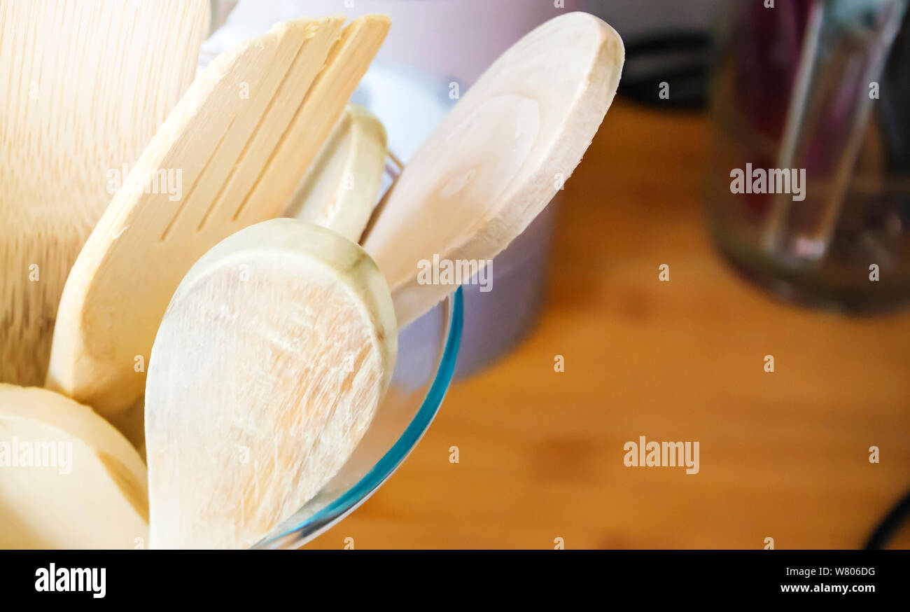 Closeup view of a group of wooden kitchen utensils inside a glass