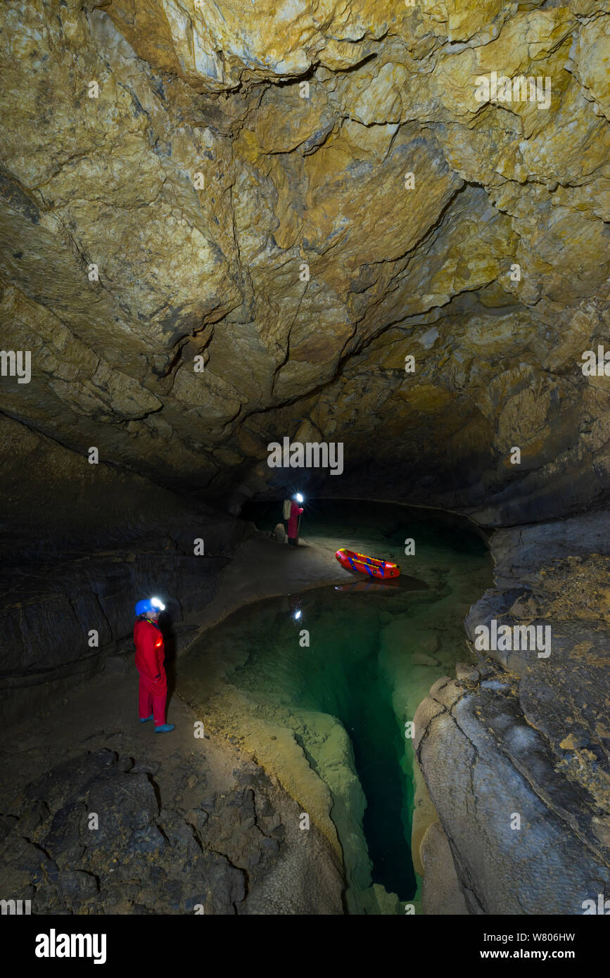 People exploring underground lakes in via rigid inflatable boat, Cross Cave (Krizna jama) under Cross Mountain, Green Karst, Slovenia, October 2014. Stock Photo