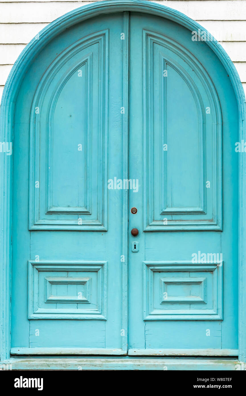 old blue wooden doors with an arch on the front of an old church Stock Photo