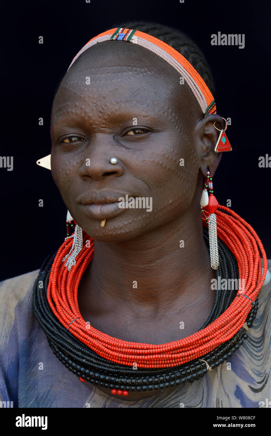 Woman from the Toposa tribe, with facial skin scarification and wearing traditional head wear and jewels, Ethiopia, Omo Valley, March 2015. Stock Photo