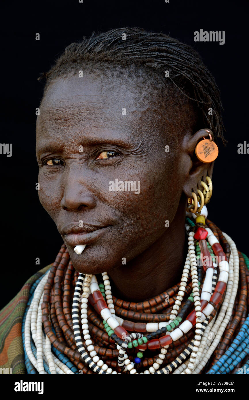 Woman from the Toposa tribe displaying facial skin scarification and traditional jewels, Ethiopia, Omo Valley, March 2015. Stock Photo