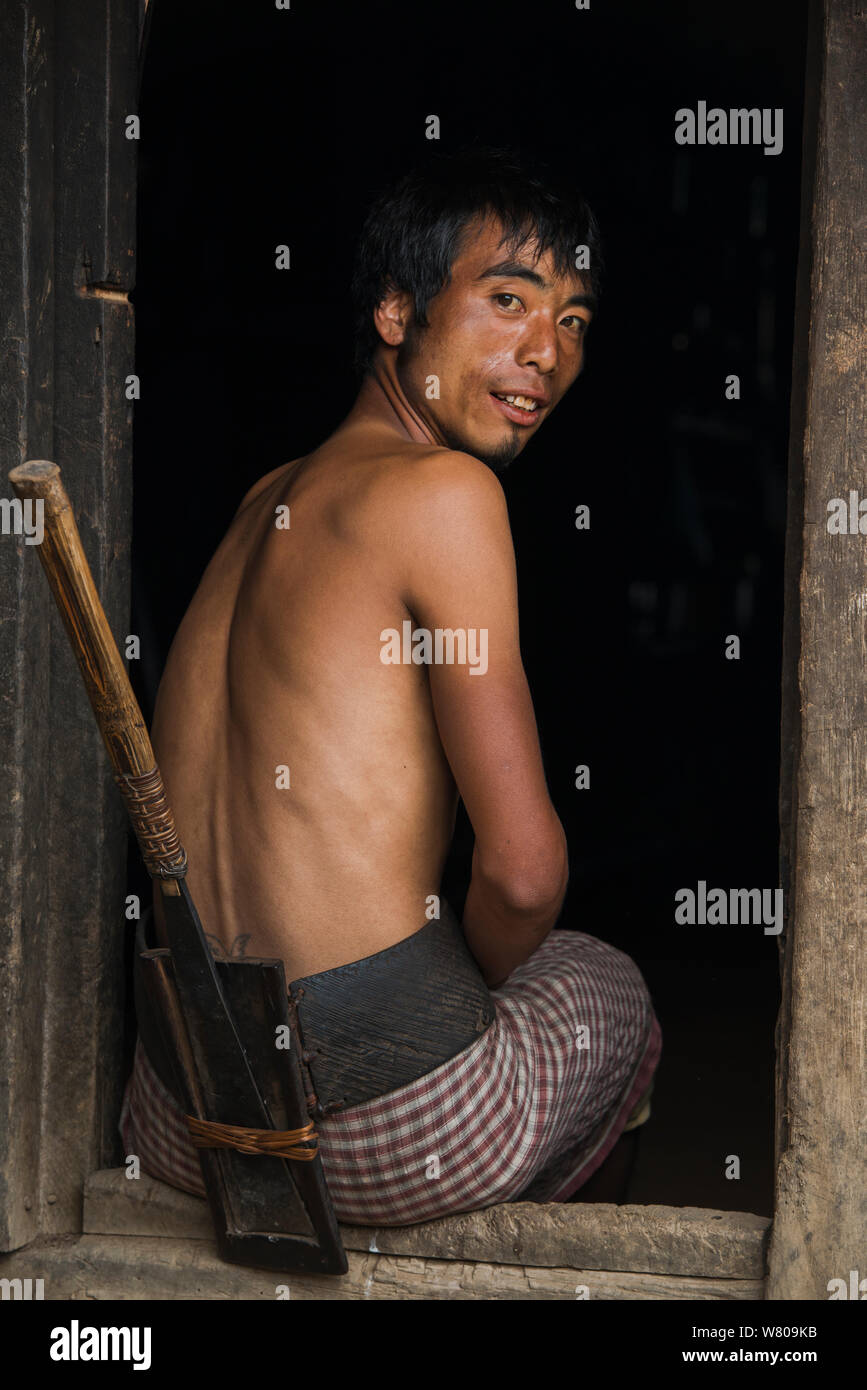 Chang Naga man with dao knife in wooden dao case attached to waist belt, Chang Naga man headhunting tribe. Tuensang district. Nagaland, North East India, October 2014. Stock Photo