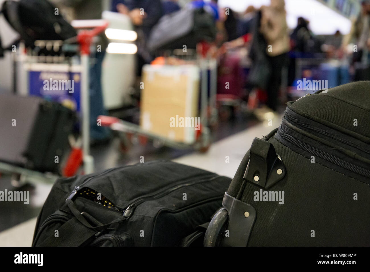Travel luggage with people and baggage in background Stock Photo