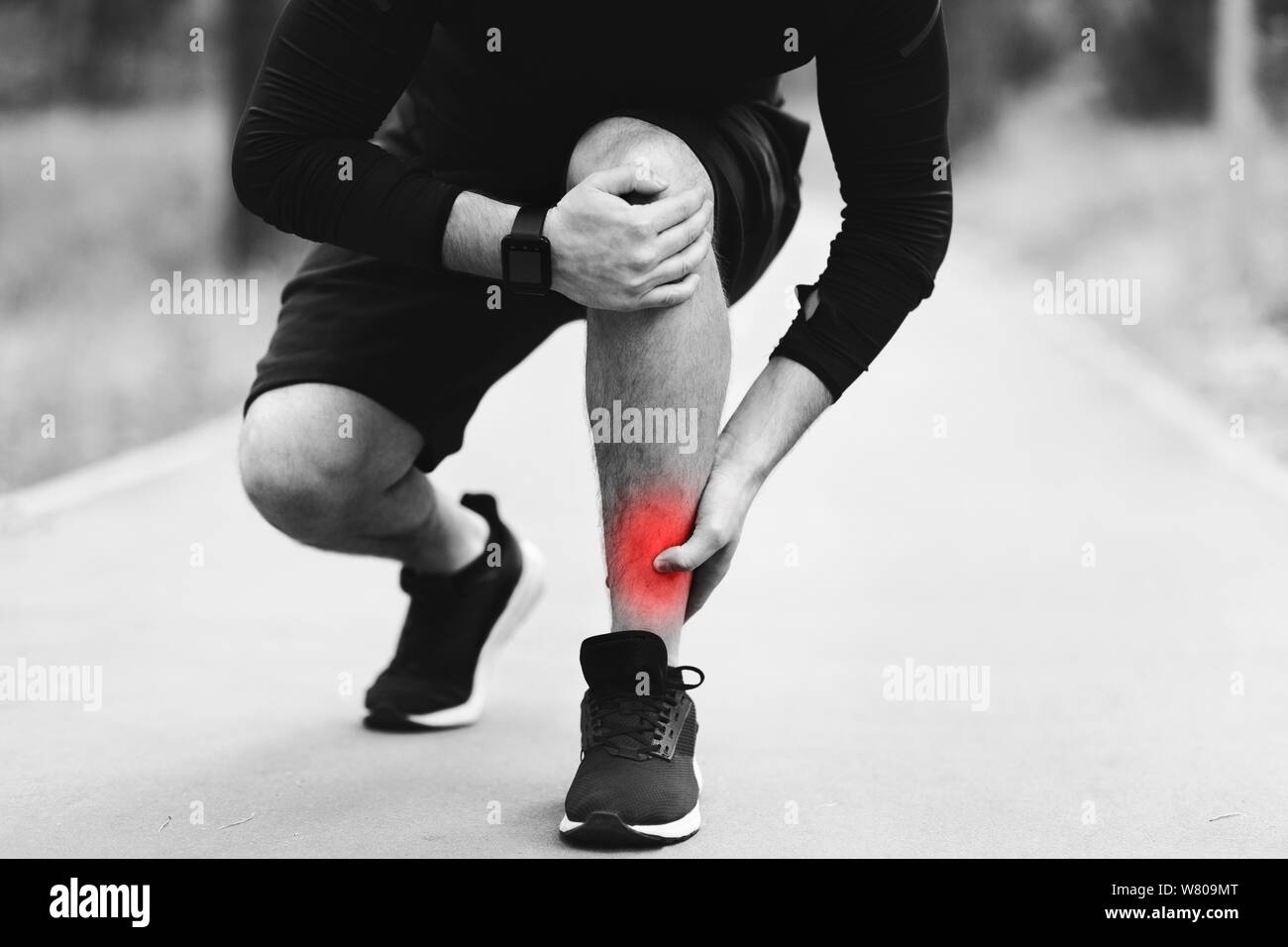 Man have sprain on leg, massaging painful muscle Stock Photo