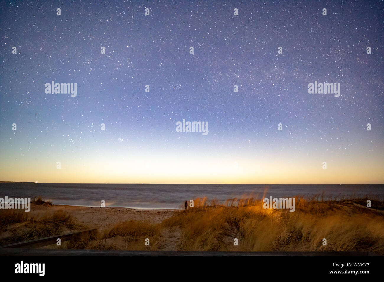 Milky way over sea at night at beach Stock Photo
