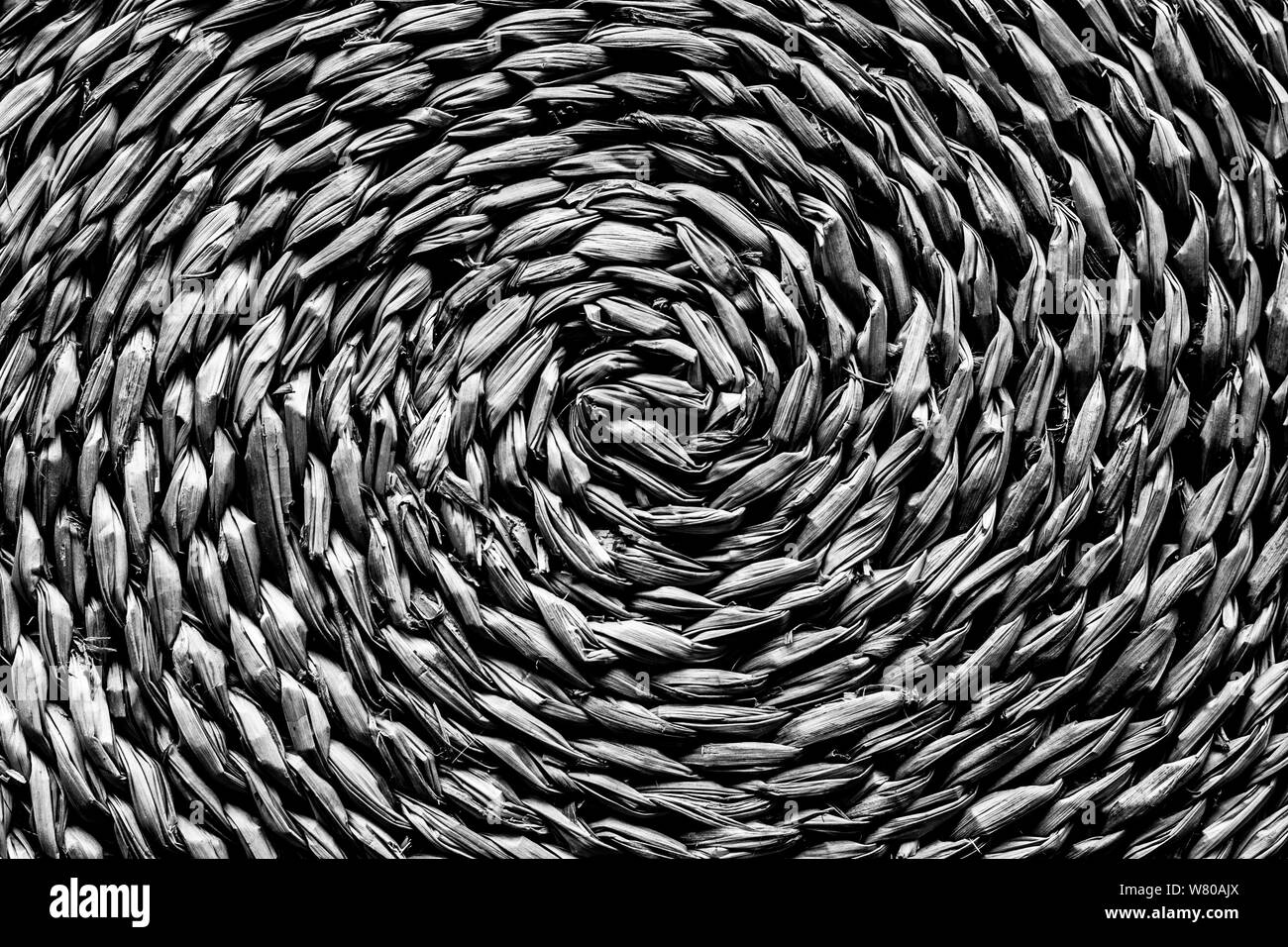 Natural straw table mat round braided, central spiral - monochrome image Stock Photo